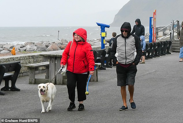 People had to wrap up warm as they enjoyed a chilly stroll along the seafront at West Bay yesterday (Sunday)