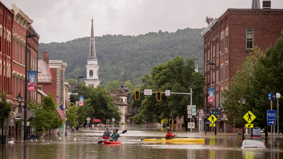 Menschen fahren mit dem Kajak durch Überschwemmungen in der Innenstadt von Montpelier, Vermont