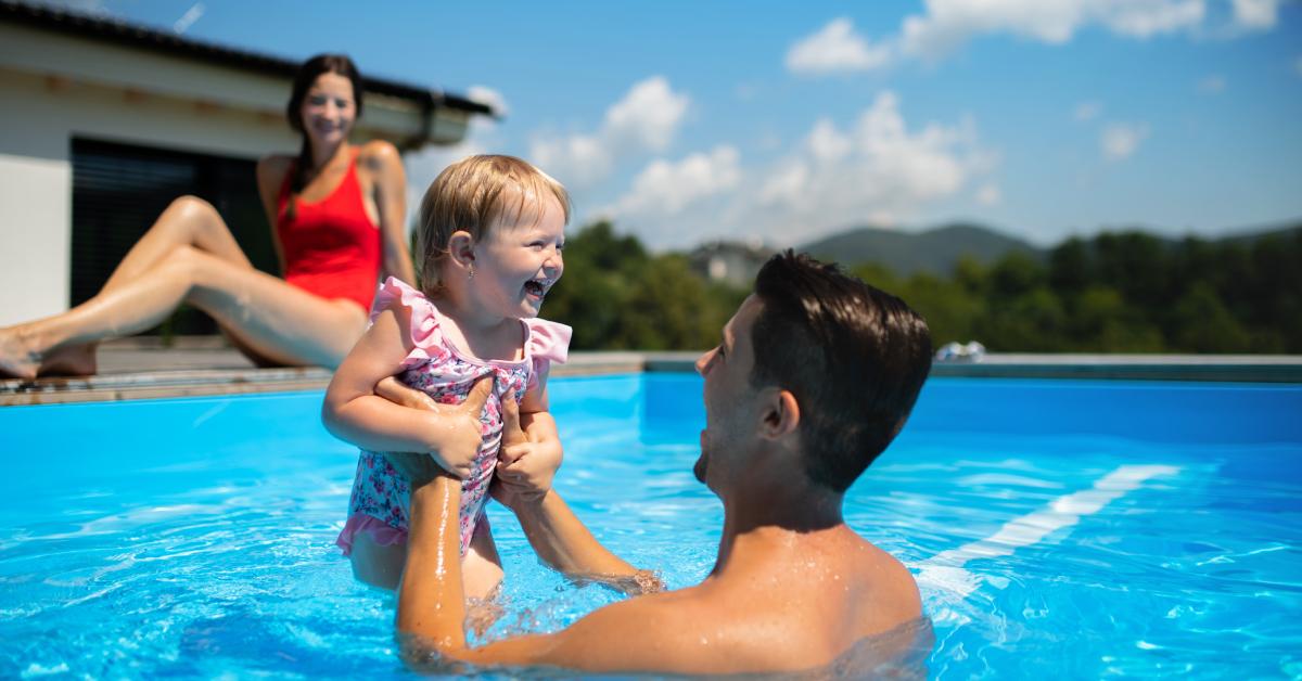 Junges Paar mit seiner kleinen Tochter im Schwimmbad.