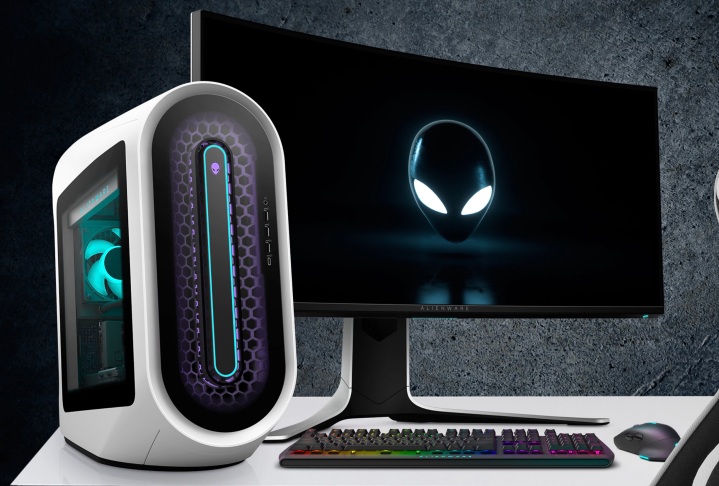 Der Alienware Aurora R13 Gaming-Desktop auf einem Schreibtisch neben einem Monitor.