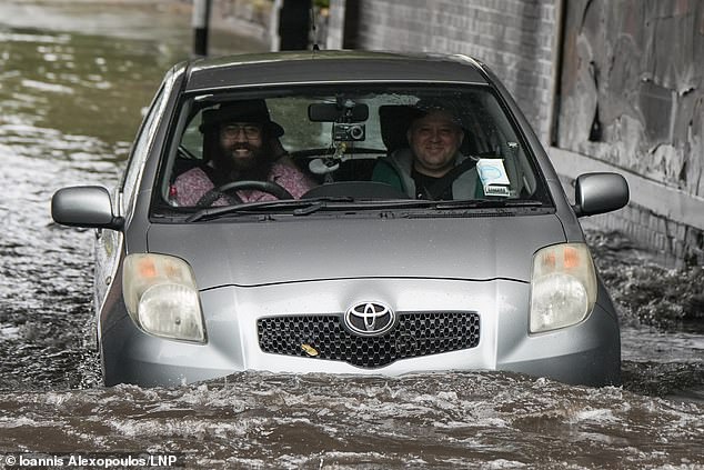 Daring motorists braved the floodwaters in Levenshulme, Manchester after heavy rain on Monday