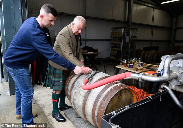King Charles reviews a cast of whisky during his tour of the new distillery in Wick, Scotland