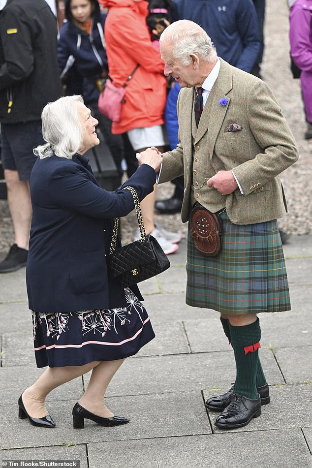 A member of the public pictured curtseying for King Charles during his visit to Wick in Scotland today