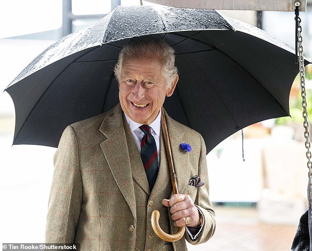 The King remained in high spirits as he shielded himself from the rain in Scotland this afternoon