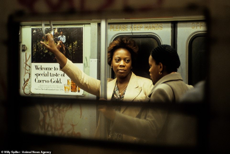 Conversation on the A-Train, Subway NY, 1982. Two passengers chat to one another beside a tequila poster in a shot taken through the window of the carriage
