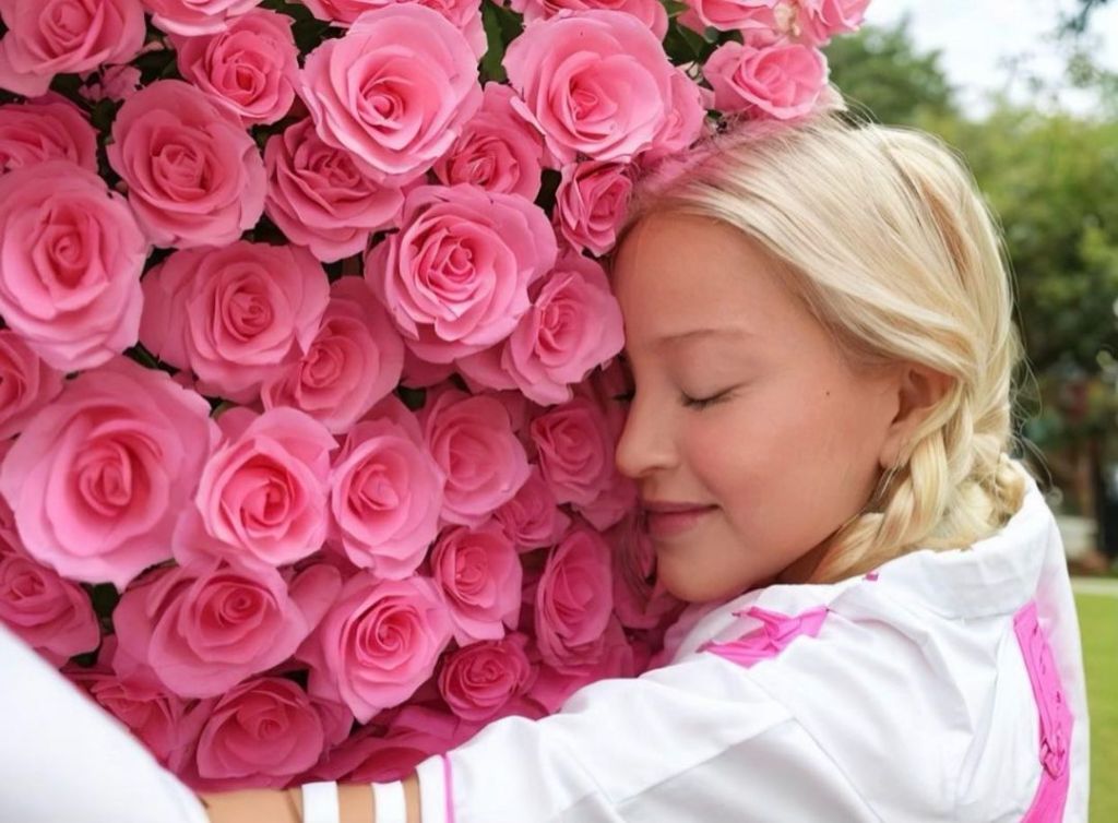 Madonna hugging a wall of roses. 