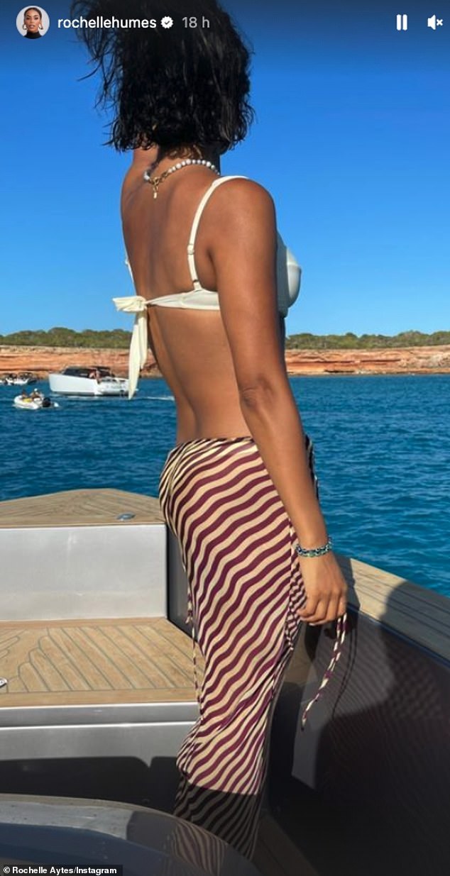 Sizzle: She showcased her jaw-dropping figure as she slipped into a white bikini which she teamed with a chic striped skirt