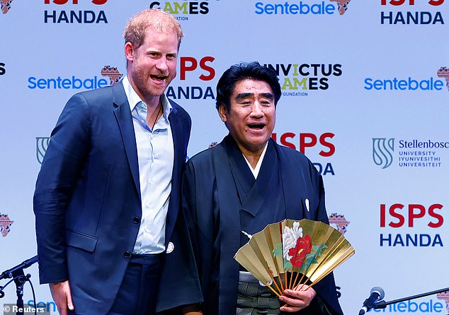 ISPS Handa's founder Haruhisa Handa and Prince Harry laugh while talking in Tokyo on Tuesday