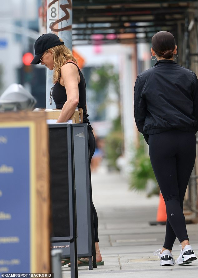 Lässig: Aniston trug eine Sonnenbrille mit goldenem Rahmen und olivgrüne Sandalen, als sie an einem Sommertag in der Stadt der Engel mit einem Karton unterwegs war