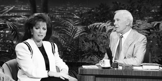 Ein Schwarz-Weiß-Foto von Jackie Collins, wie er von Johnny Carson interviewt wird
