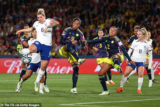 Millie Bright of England shoots under pressure from Mayra Ramirez and Manuela Vanegas of Colombia