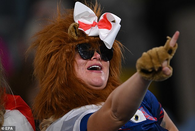 An England fan with a St George bow reacts excitedly during the first half
