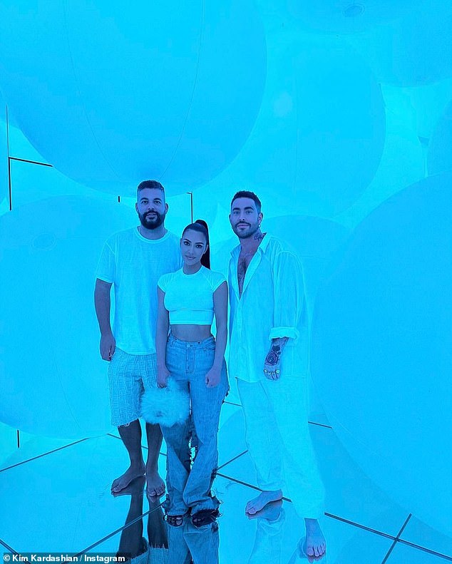 Barfuß: Kim und zwei barfüßige Männer stehen auf einem verspiegelten Boden vor etwas, das wie riesige weiße Luftballons aussieht
