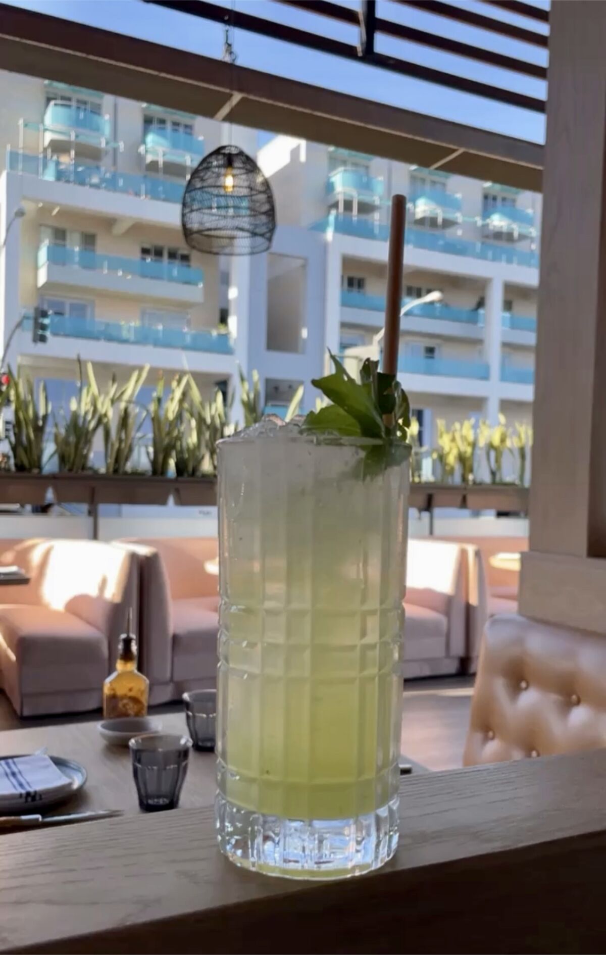 Ein Cocktail in einem hohen Glas steht auf einer Fensterbank.