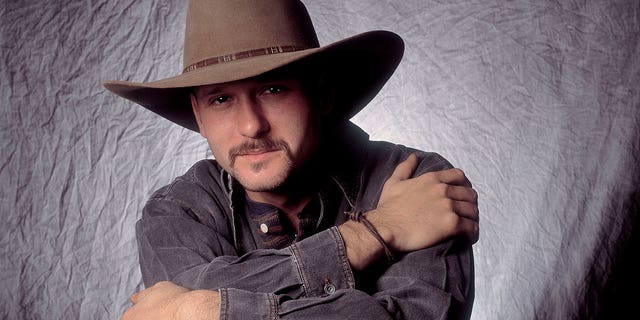 Tim McGraw posiert mit Cowboyhut und Langarmshirt