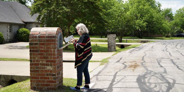 Frau geht hinaus, um ihre Post zu holen