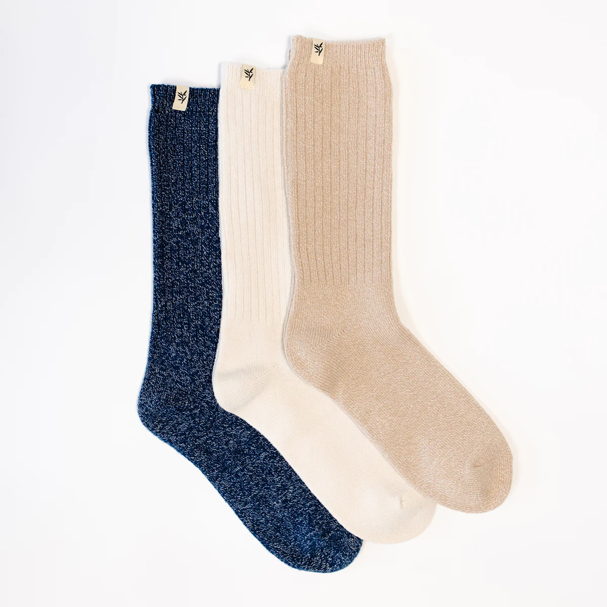 Ein Set mit drei Socken, einmal marineblau, einmal weiß und einmal braun