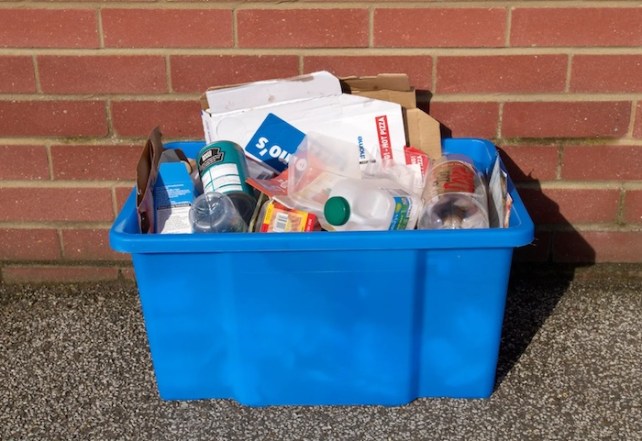 Eine Recyclingbox mit gemischtem Kunststoffabfall und anderen Materialien.