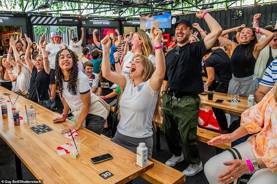 Fans in the Boxpark Shoreditch in East London watch as England take the lead in the match today