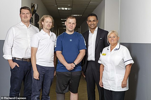 In November 2022, 15 weeks after the accident, Zoltan was able to take his first steps since having part of his leg amputated. Pictured, Zoltan at Charing Cross Hospital with Chris Jordan, consultant orthopaedic surgeon (far left), Jack Murray, prosthesist (left), Kshem Yapa, consultant plastic surgeon (right) and Laura Burgess, clinical specialist physiotherapist (far right)