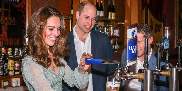 Kate Middleton trägt ein hellgrünes Kleid und arbeitet an der Bar, während Prinz William zusieht