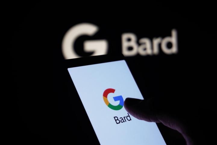 Eine Person hält ein Telefon mit dem Google-Logo und dem Wort „Bard“ auf dem Bildschirm.  Im Hintergrund ist ein Google Bard-Logo zu sehen.