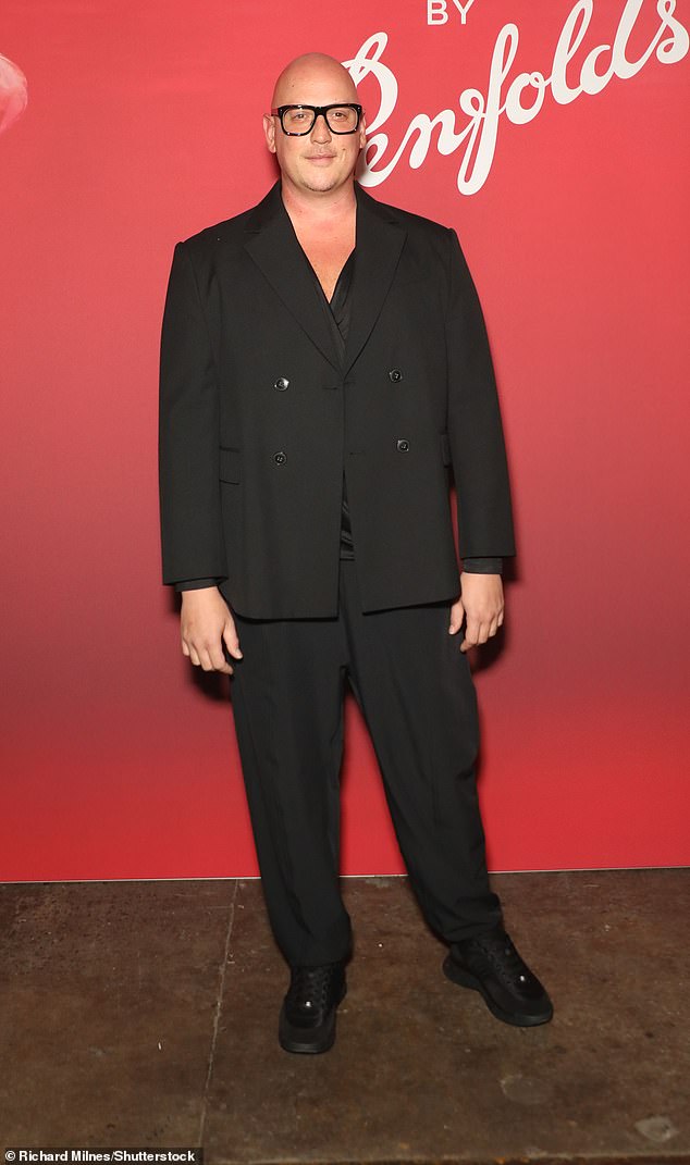 Modedesigner Michael Lo Sondo trug einen komplett schwarzen Anzug mit passenden Turnschuhen und einer Lesebrille