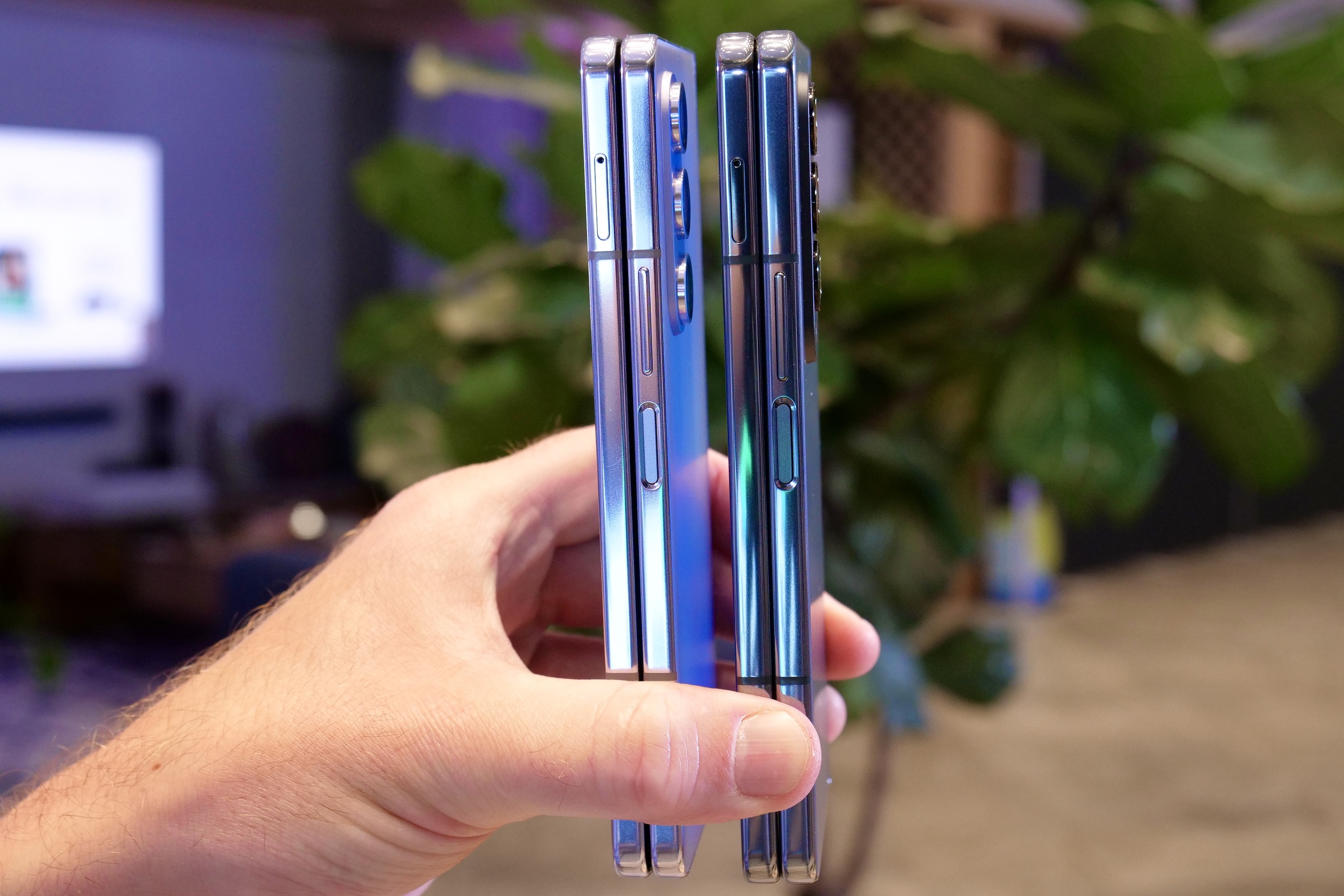 A person holding the Samsung Galaxy Z Fold 4 and Galaxy Z Fold 5, seen from the side.