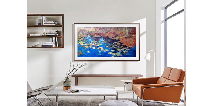 Der 65-Zoll-QLED-Fernseher The Frame von Samsung hängt an der Wand in einem attraktiven Wohnzimmer.