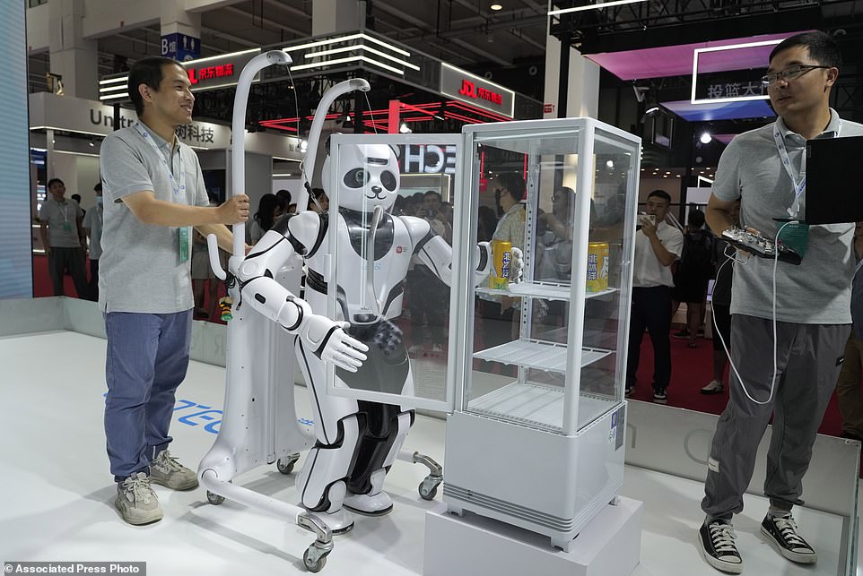 A panda shaped robot demonstrates its ability to grab open a cabinet and grab a can of soda from within