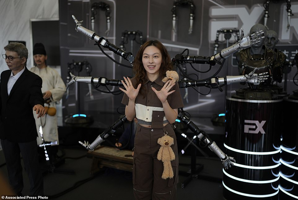 A woman poses in front of a six armed robot, which could be used as an extension of a human's body