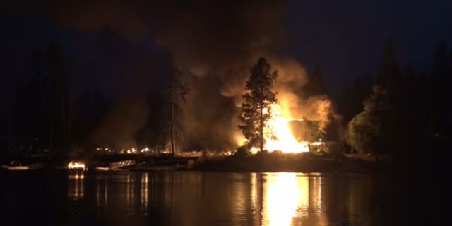 Graues Feuer brennt in der Nähe des Sees