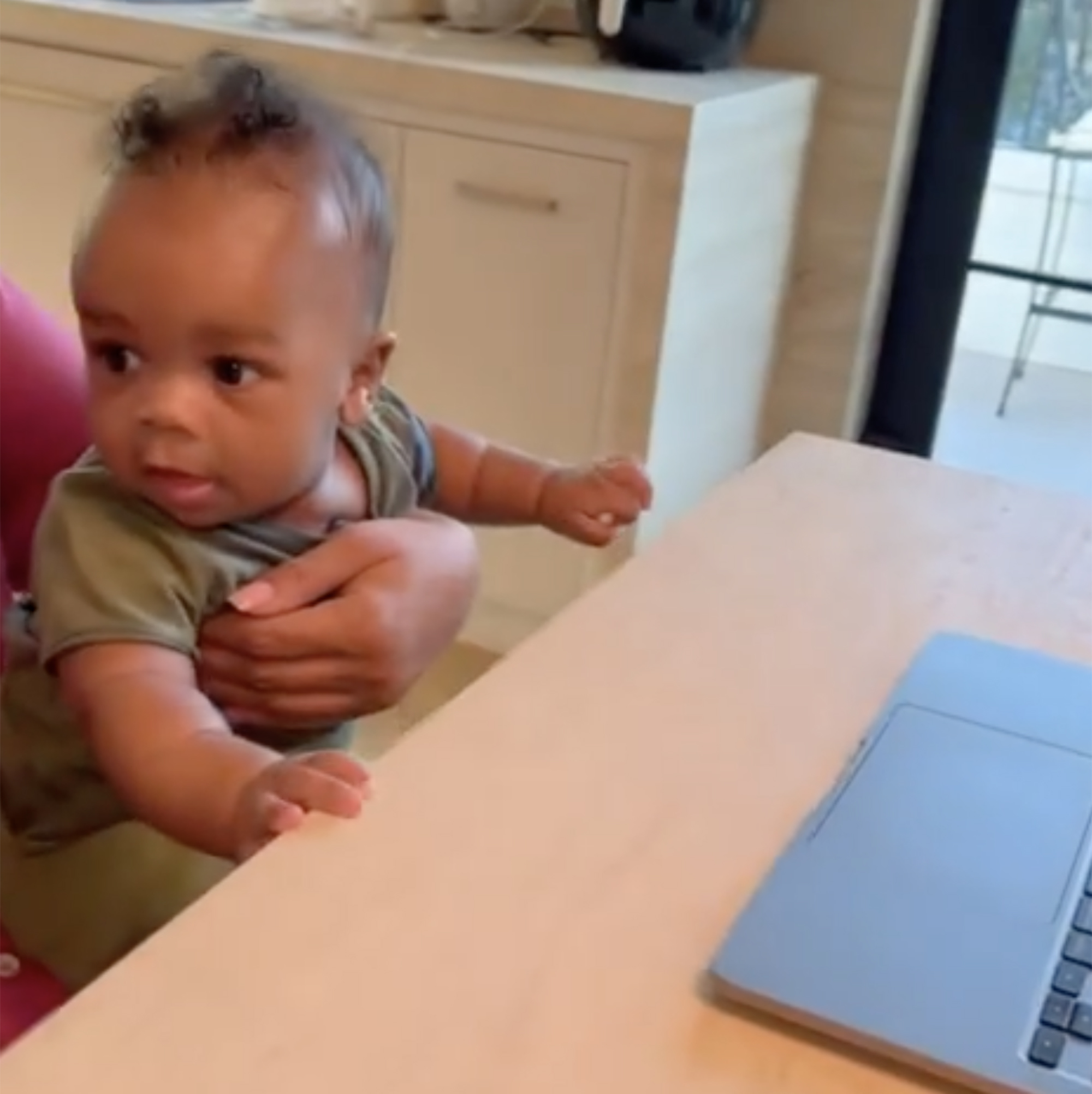 Rihannas Sohn sitzt am Tisch vor dem Laptop