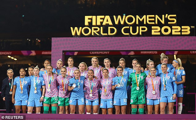Die Lionesses lächeln trotz des Schmerzes, während sie nach einer schmerzhaften WM-Finalniederlage mit ihren Zweitplatzierten-Medaillen posieren