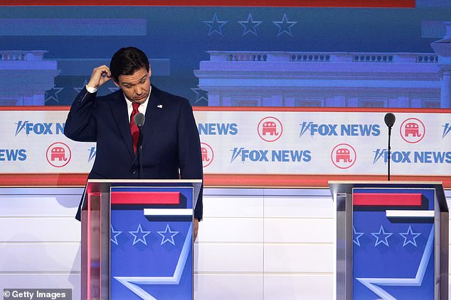Ron DeSantis scratches his head during a commercial break in the debate
