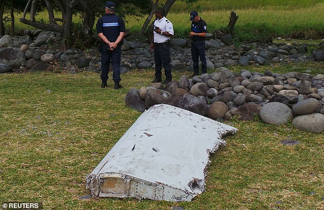 Barnacle shells on parts of Malaysia Airlines flight MH370 that washed up can reveal more about what happened to the plane, experts say. Pictured, authorities stand near a piece of barnacle-covered plane debris (part of the wing known as a flaperon) in Saint-Andre, on the French Indian Ocean island of La Reunion, in this picture taken on July 29, 2015
