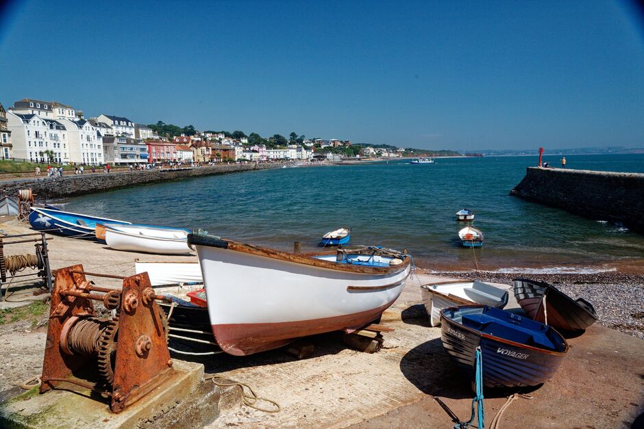 Dawlish England. Long view across the bay and rowing boats to the town in sun.