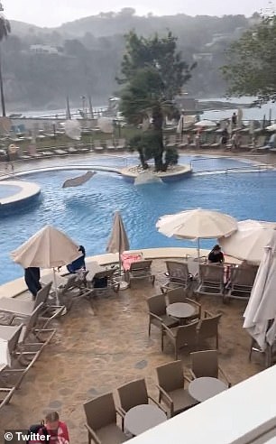 Fassungslose Urlauber haben Aufnahmen von Touristen geteilt, die Schutz suchten, als Sonnenliegen von den heftigen Winden in Schwimmbäder geschleudert wurden.