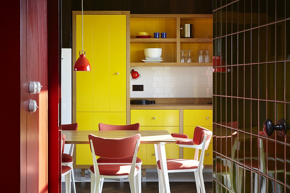 „Wenn Sie durch die Vordertür treten, erstrahlt der Ort voller Farben“, schreibt Kate, „von den roten und gelben Türen und der Täfelung der ansonsten funktionalen Küche bis zum dreifach hohen Wohnbereich mit seinen riesigen, farbenfrohen Wandteppichen und Mosaikböden.“