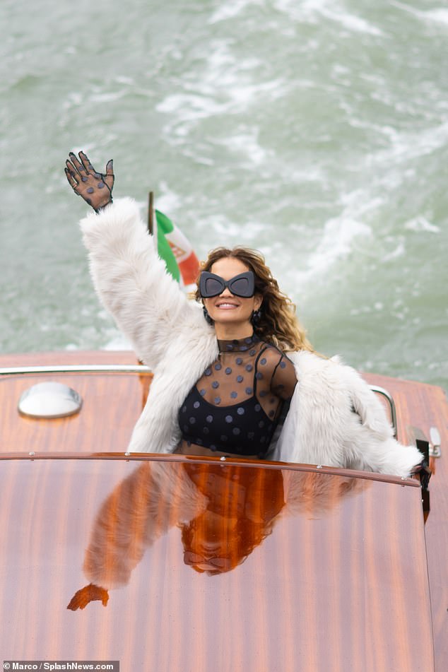 Quiet arrival: Rita Ora was seen arriving in Venice wearing a sheer top and white fur jacket