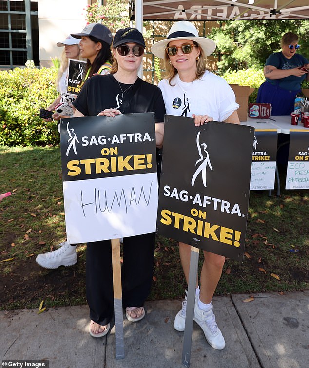 Stars: Amy Adams carrying a SAG-AFTRA On Strike, adding the word 'Human' to it during her picket; seen with Elizabeth Banks