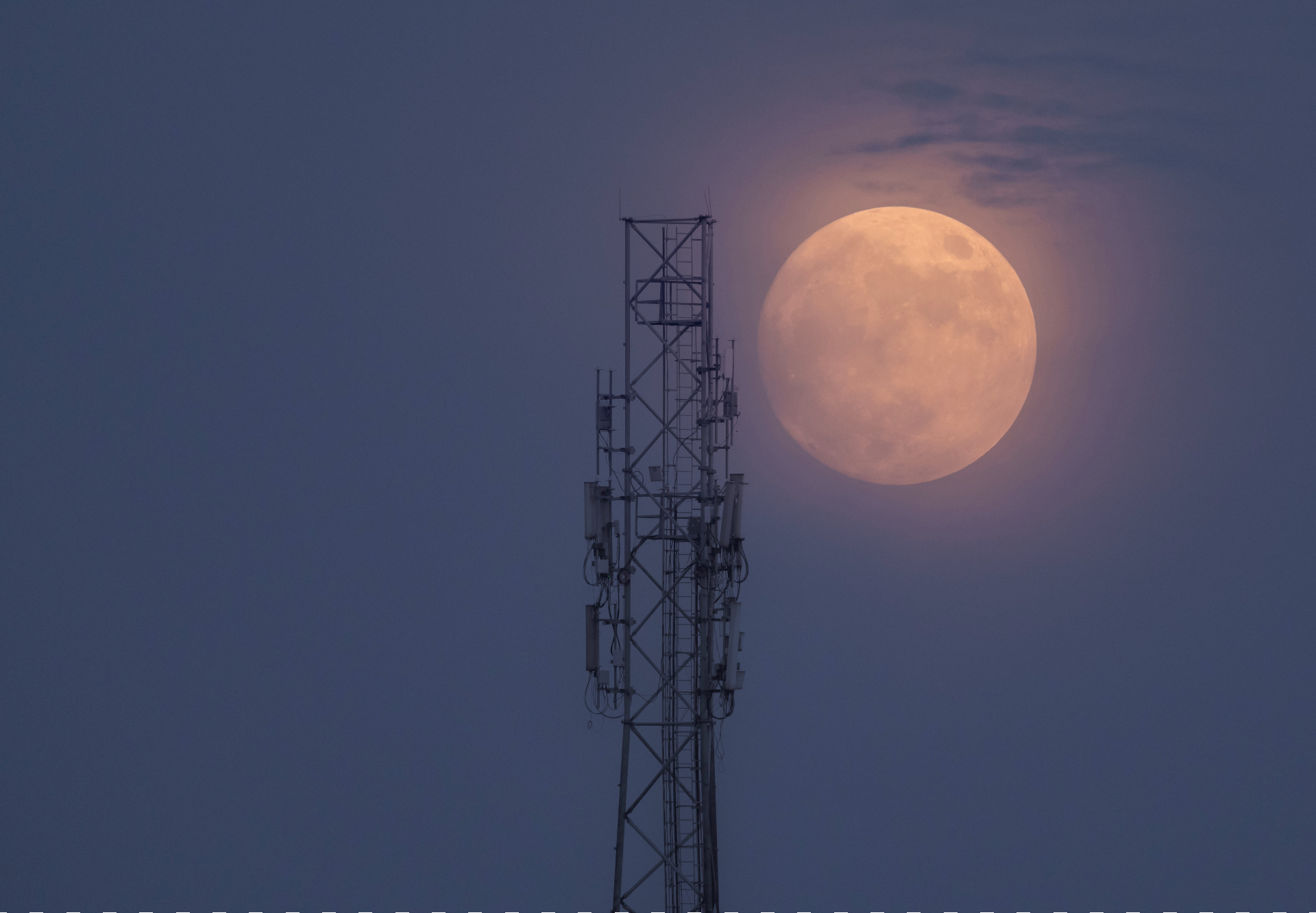 Super Blue Moon leuchtet neblig orange neben einem Turm.