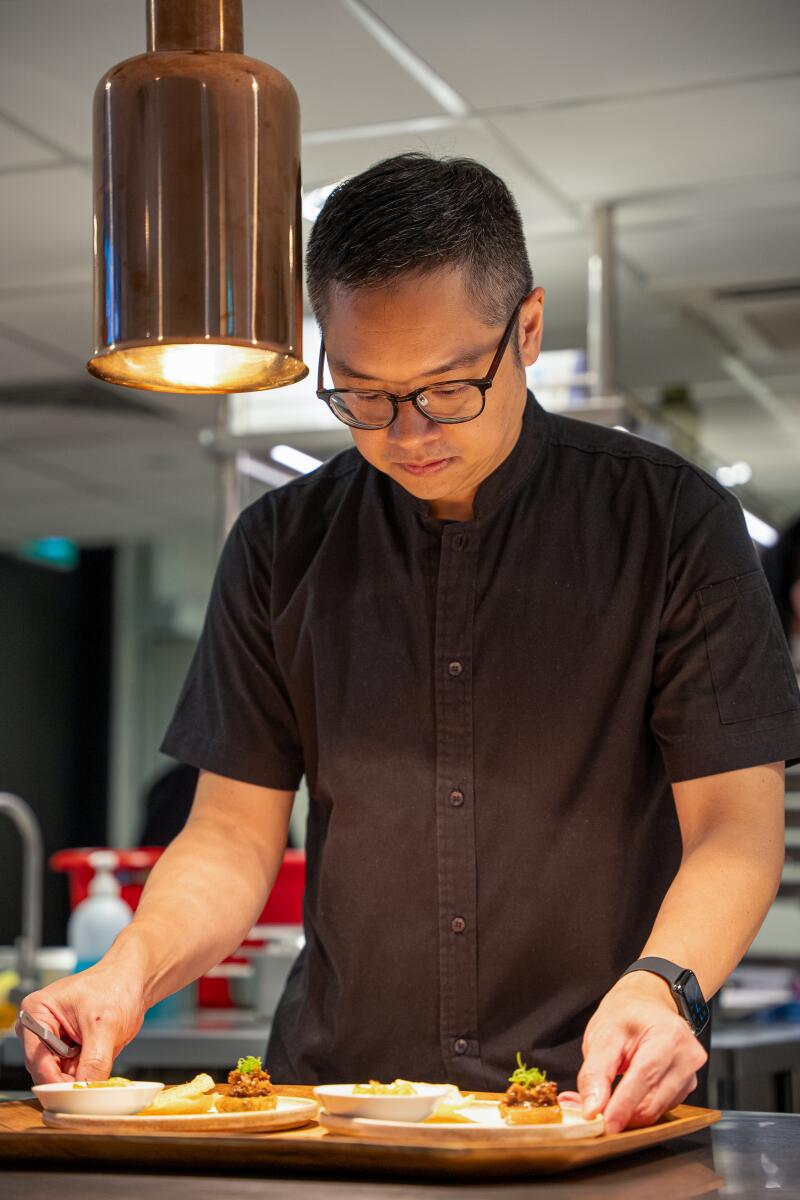 Chefkoch Malcolm Lee bereitet in der Küche des Restaurants Pangium in Singapur ein Gericht zu.