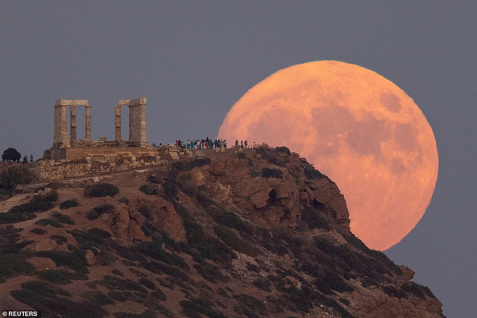 GRIECHENLAND: Ein Vollmond, bekannt als „Blauer Mond“, geht hinter dem Tempel des Poseidon am Kap Sounion in der Nähe von Athen auf
