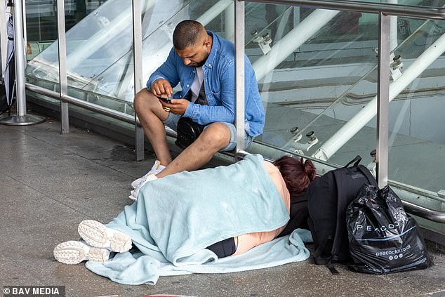 Ein Passagier schläft heute am Flughafen Stansted auf dem Boden, während das anhaltende Flugchaos anhält