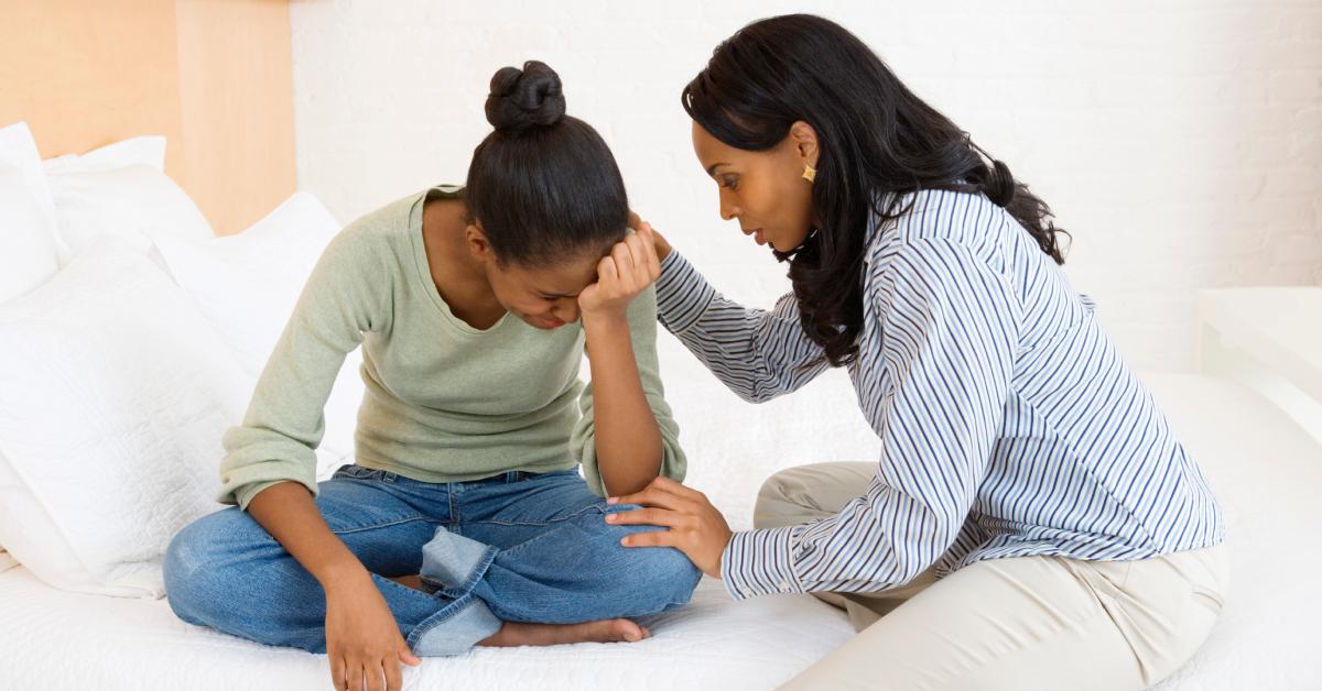 Eine Mutter tröstet ihre weinende Tochter im Teenageralter.