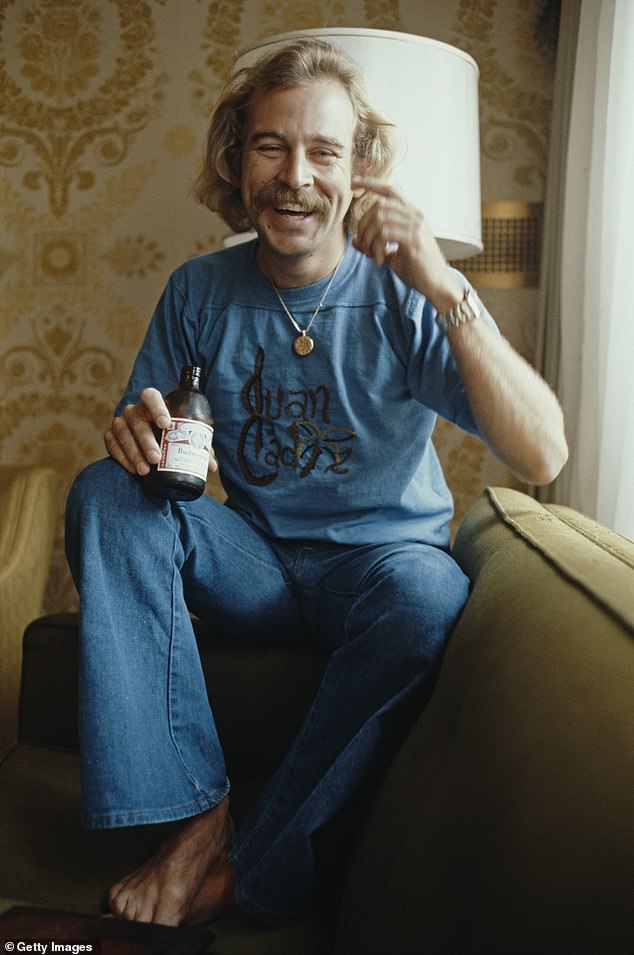 Jimmy Buffett is pictured holding a bottle of Budweiser beer during an interview in New York in 1977, the year his smash-hit 'Margaritaville' was released