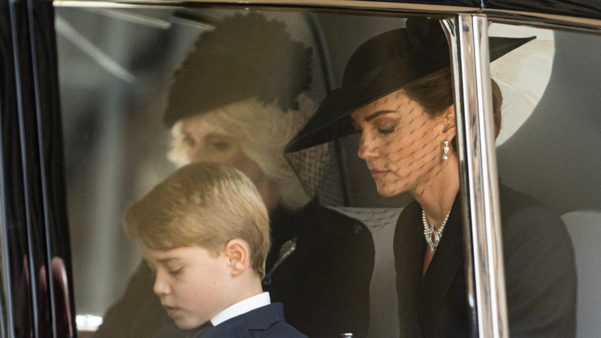 Kate Middleton, Königin Camilla und Prinz George tragen Schwarz und schauen von der Kamera weg