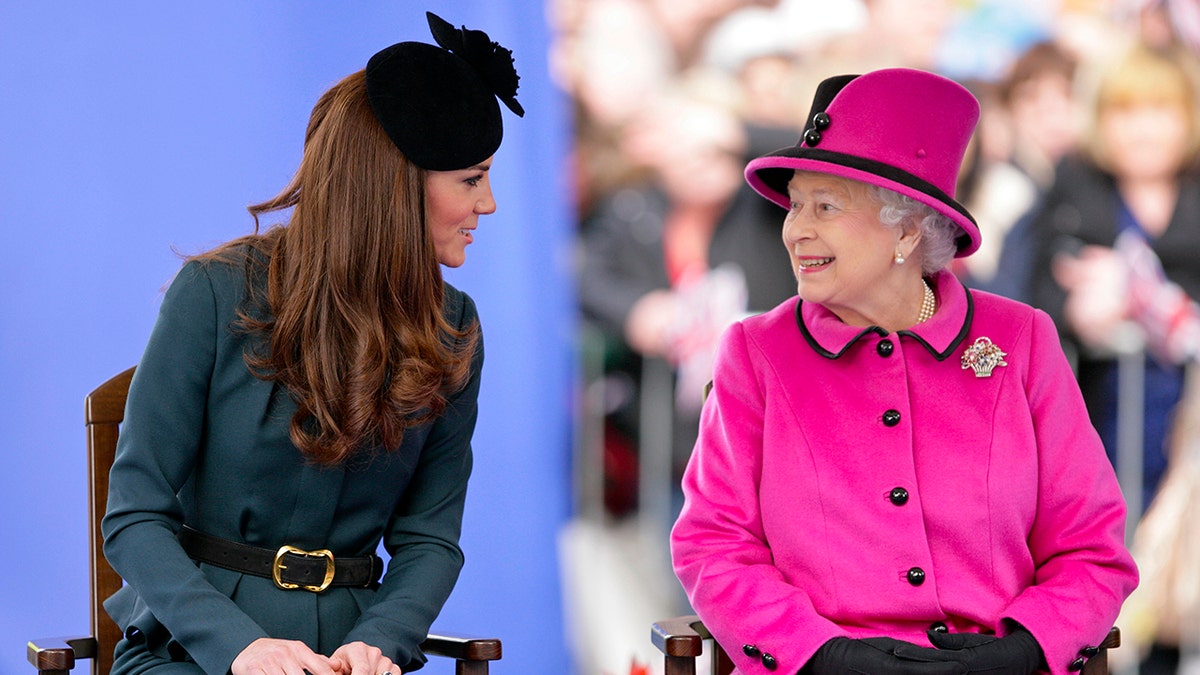 Kate Middleton trägt ein jägergrünes Kleid und sitzt neben Königin Elizabeth in einem leuchtend rosa Kleid
