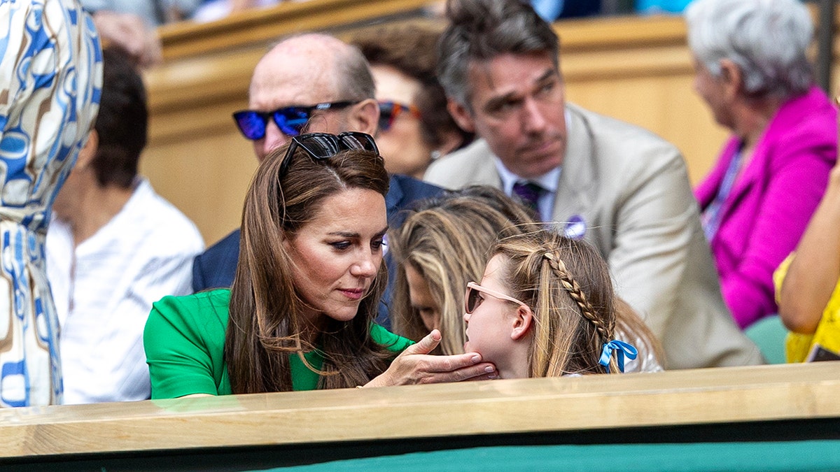 Kate Middleton in einem leuchtend grünen Kleid streichelt das Gesicht ihrer Tochter